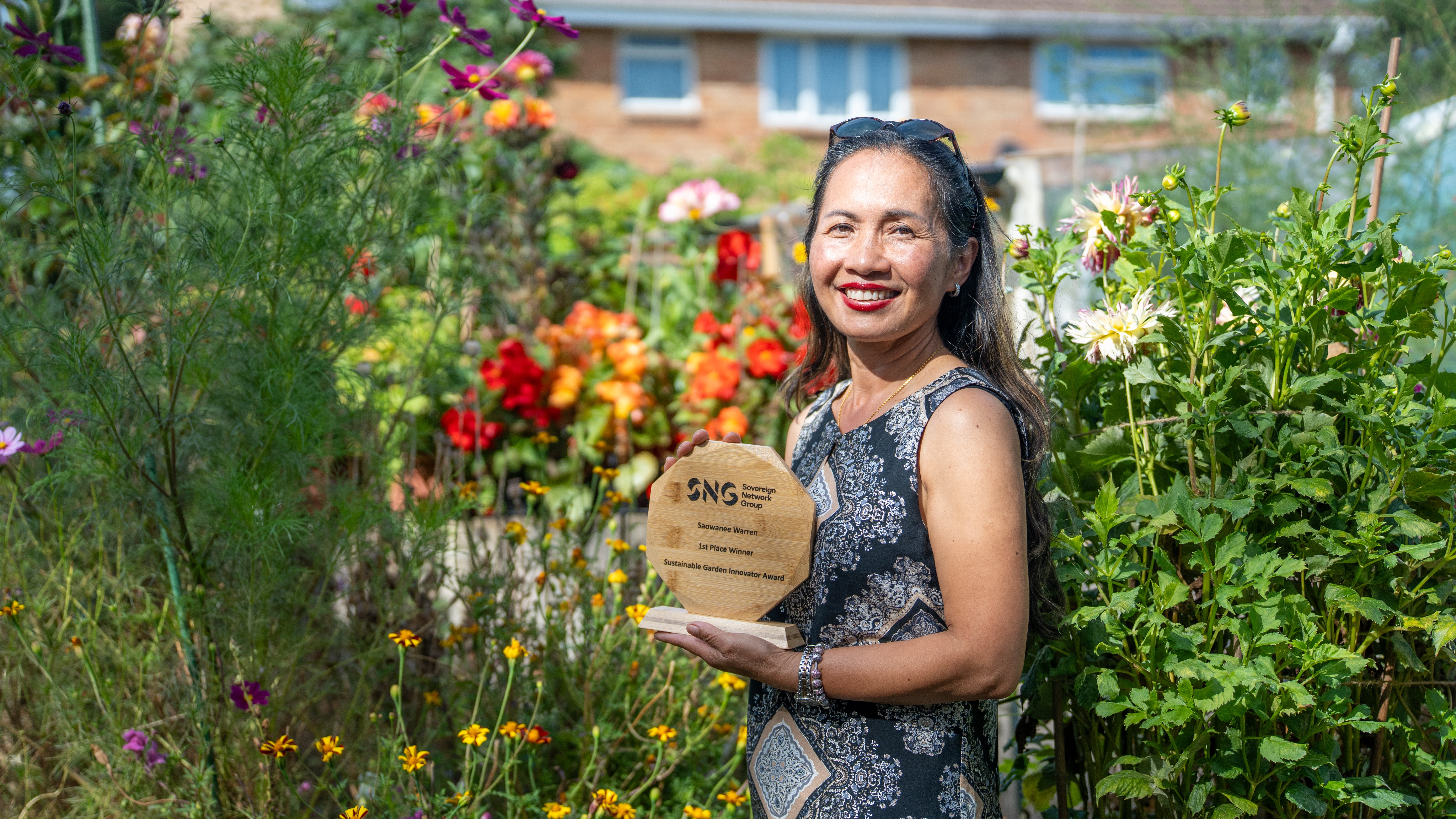 Sustainable garden winner with her trophy in her garden