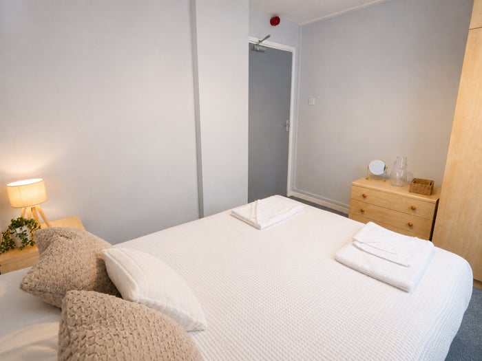 Spacious double bedroom with bed, wardrobe and bedside tables