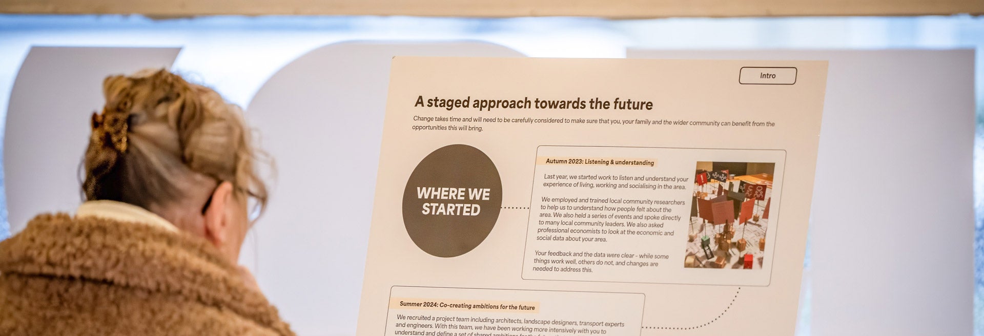 Person reading a display board about a staged approach to the future.