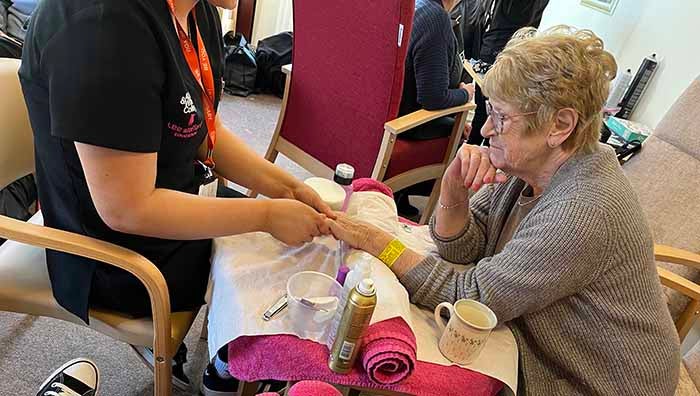 A pensioner getting her nails done