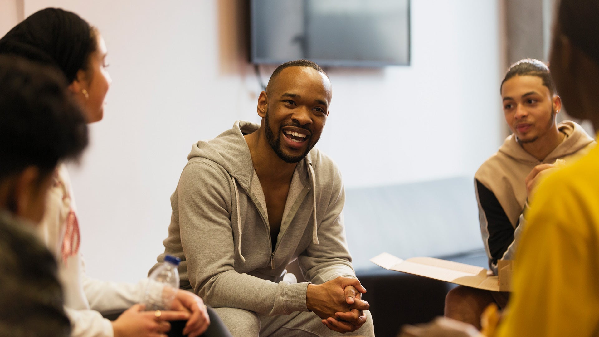 Smiling male mentor talking to teenagers