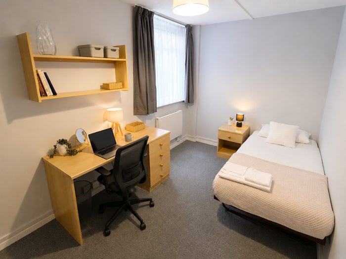Single bedroom with study desk, shelving and storage furniture