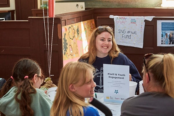 A lady engaging in conversation while leading an interactive #iwill and Youth Engagement stall