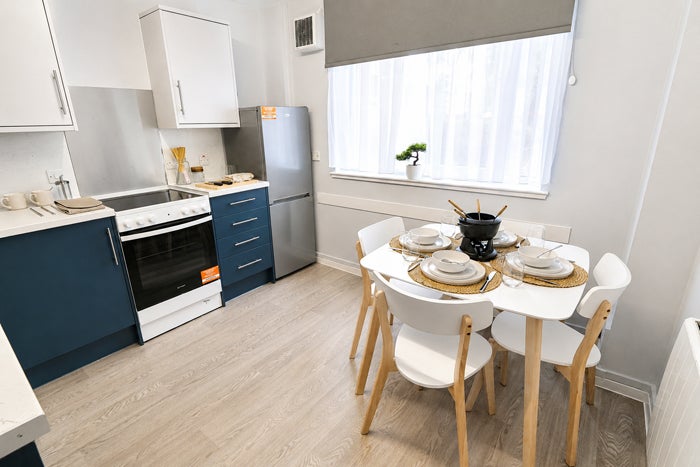 Shared kitchen and dining space with table and chairs