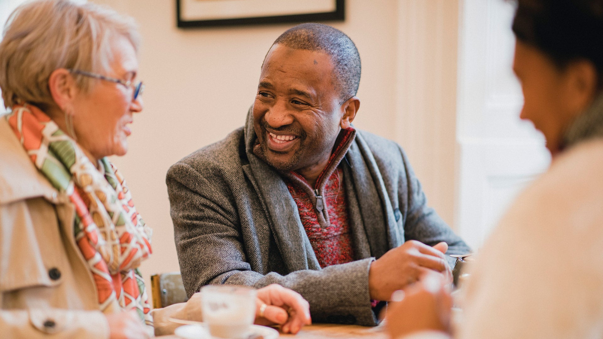 A group of people sitting at a table enjoying coffee and a chat