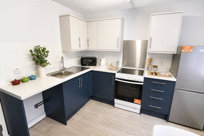 Contemporary kitchen with oven, fridge freezer and ample worktop space