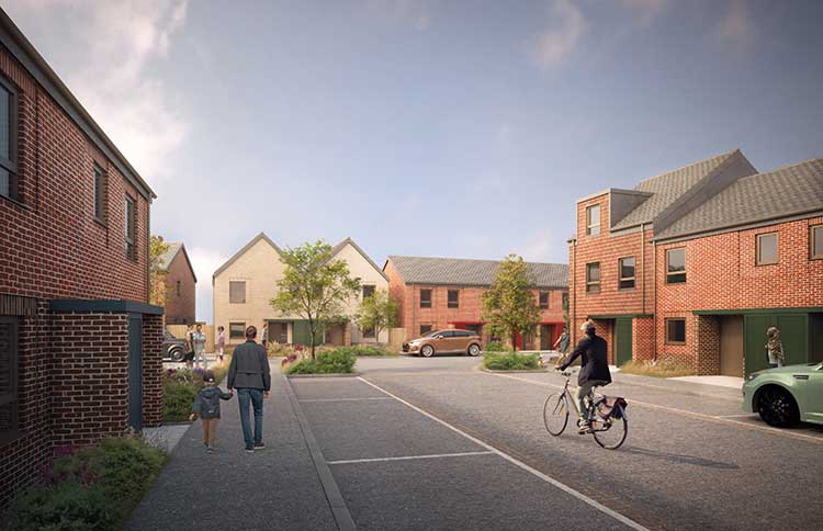 Shared residential street within a new housing development, featuring red-brick homes, landscaped planting, and people walking and cycling along a wide pedestrian-friendly route lined with young trees.