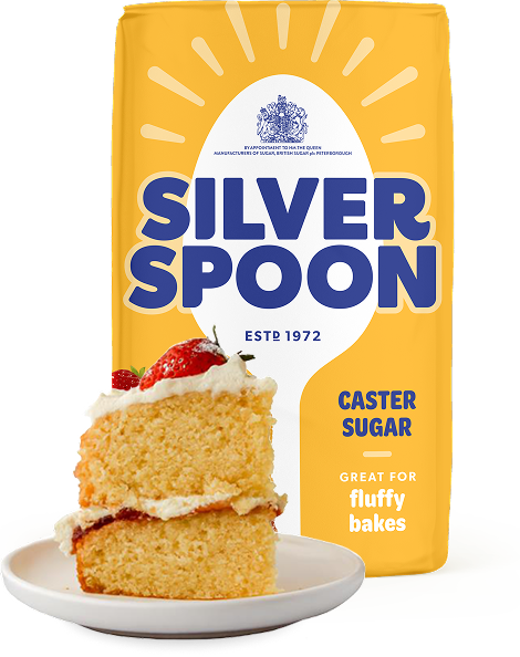 A yellow pack of Silver Spoon caster sugar with a slice of Victoria sponge cake placed to the front of it.