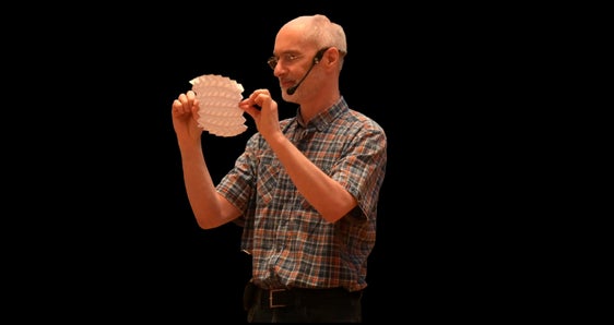 Referent Norbert Hungerbühler bei seinen Ausführungen über die mathematischen Hintergründe des Papierfaltens. (Foto: LPA/Deutsche Bildungsdirektion/Margit Pichler)