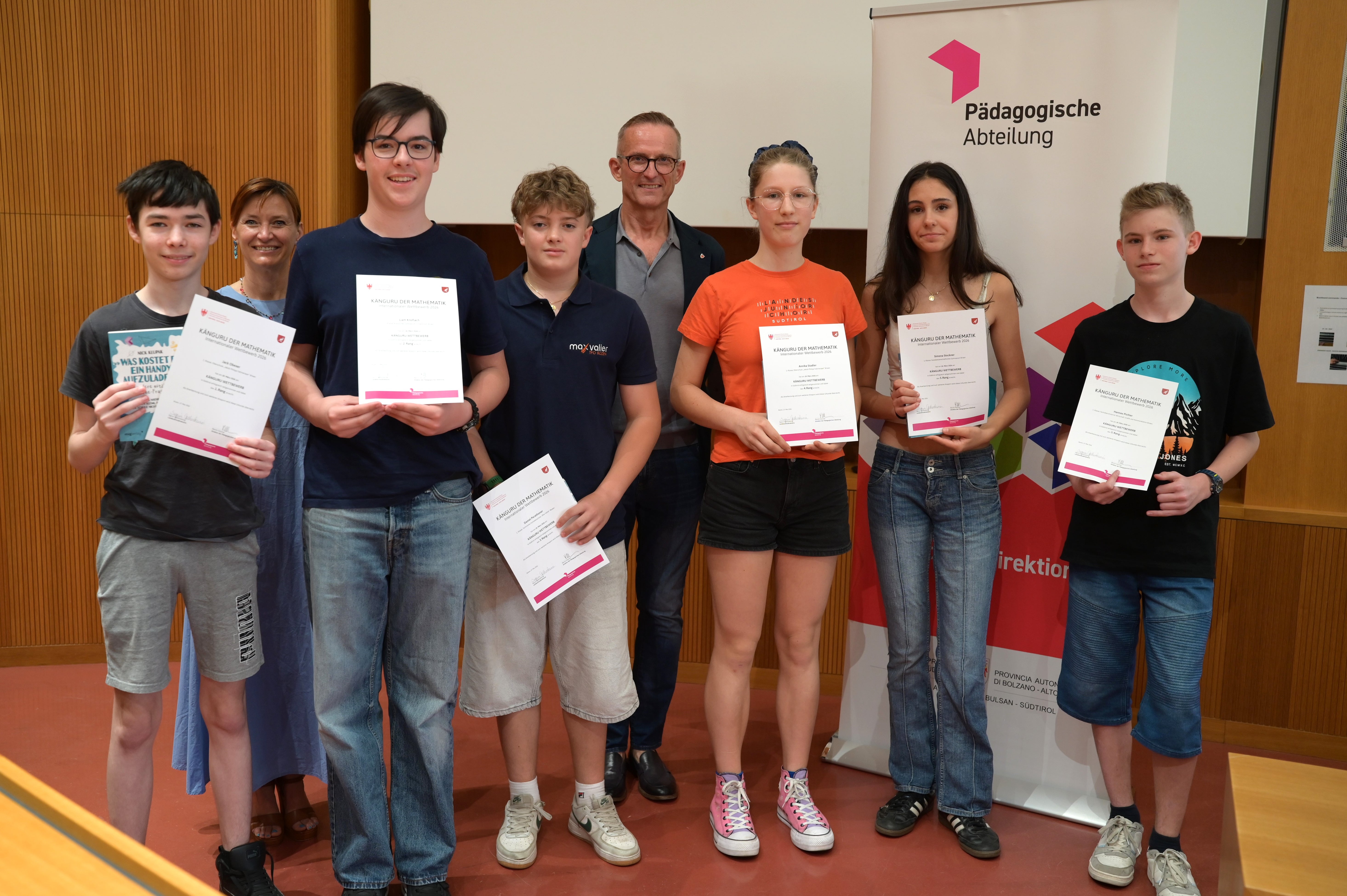 Prämierungsfeier Känguru der Mathematik 2026: 1. Klasse Oberschule Kategorie Junior (von links): Jack Obexer, Landesschuldirektorin Sigrun Falkensteiner, Liam Knoflach, Daniel Perathoner, Abteilungsdirektor Martin Holzner, Annika Stadler, Simona Stockner, Hannes Pichler (Foto: LPA/Deutsche Bildungsdirektion/Margit Pichler)