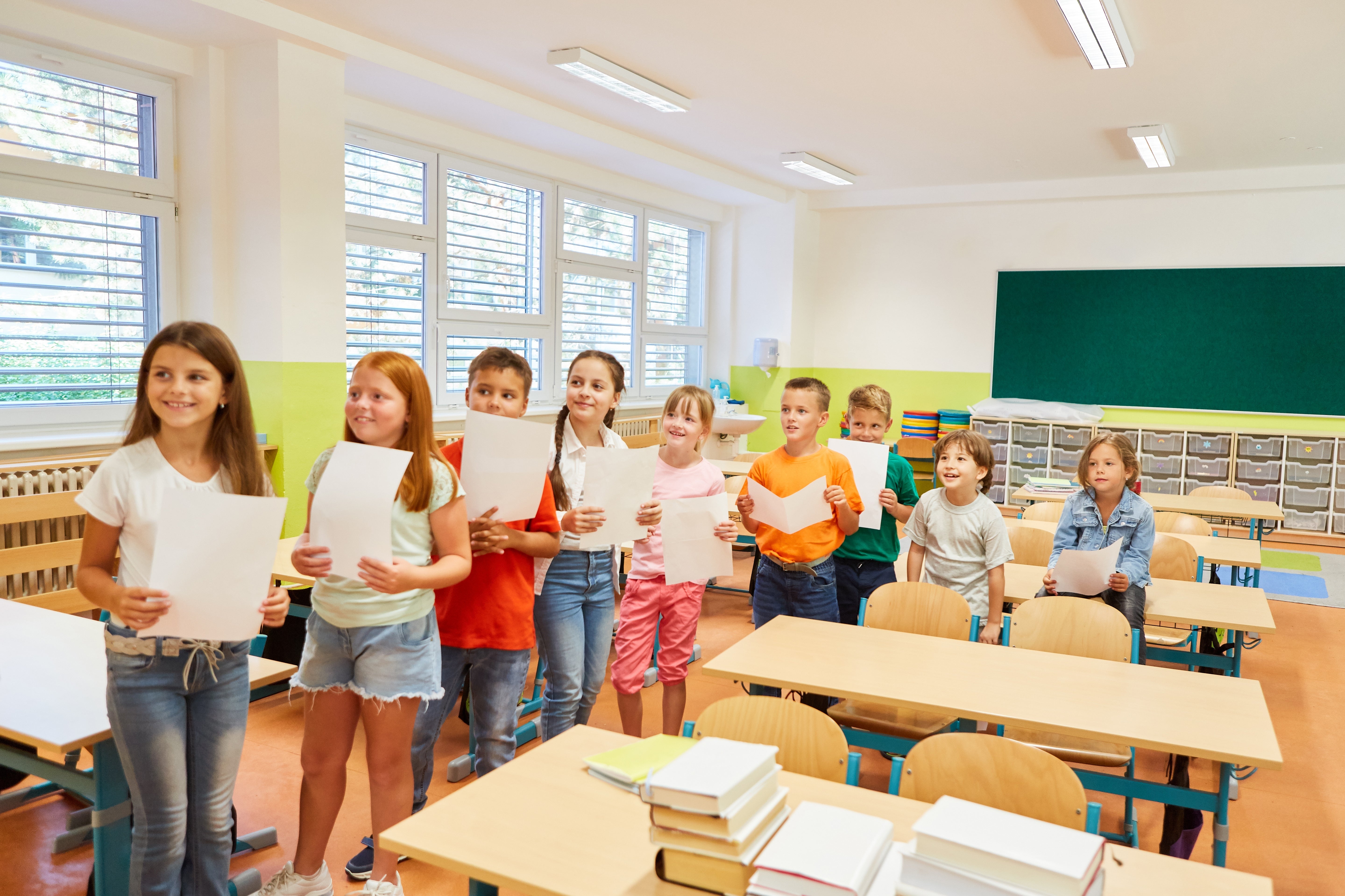 Kinder warten freudig mit einem Blatt in der Hand (Foto: Shutterstock)