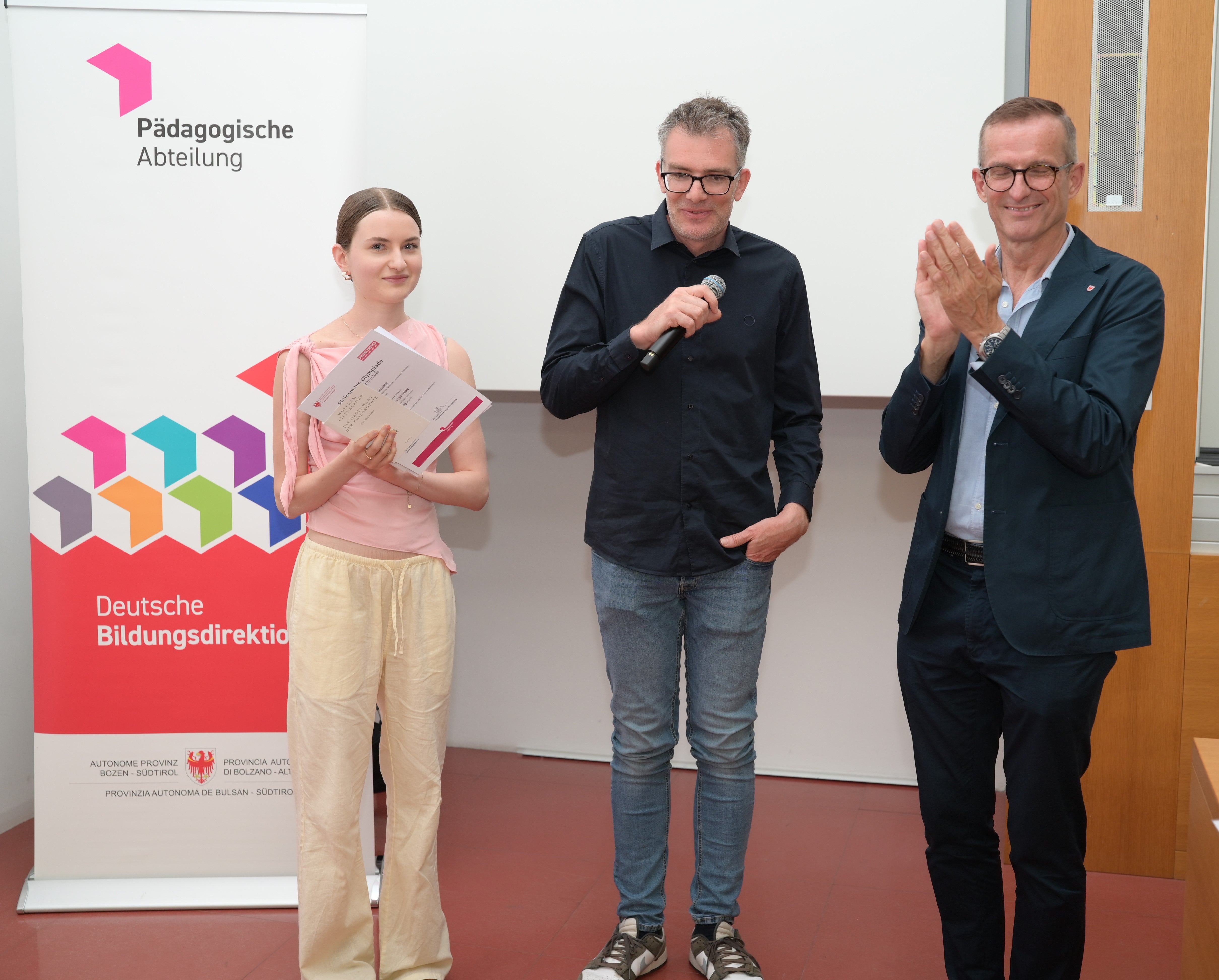 Greta Reinstadler vom Sozialwissenschaftlichen, Klassischen, Sprachen- und Kunstgymnasium in Meran (links) qualifizierte sich für den österreichischen Bundeswettbewerb in Salzburg; im Bild mit dem Landeskoordinator der Philosophie-Olympiade Stefan Goller (Mitte) und Abteilungsdirektor Martin Holzner (rechts). (Foto: LPA/Deutsche Bildungsdirektion/Margit Pichler)