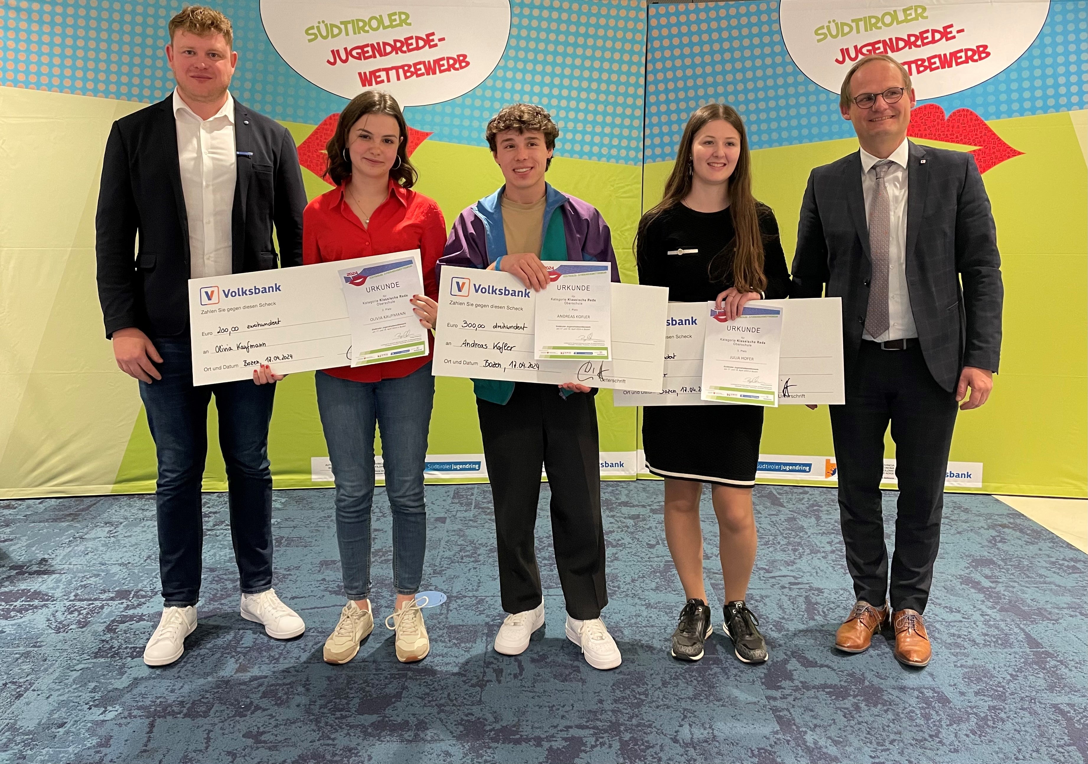 Sie überzeugten mit ihrem Redetalent und ihren schauspielerischen Fähigkeiten und siegten in der Kategorie Klassische Rede/Oberschule: (von links) Olivia Kaufmann, 2. Platz; Andreas Kofler, 1. Platz , Julia Hofer, 3. Platz; (links und rechts außen) Philipp Tarfusser (Südtiroler Jugendring), Hannes Wieser (Volksbank) Foto: Ulrike Huber