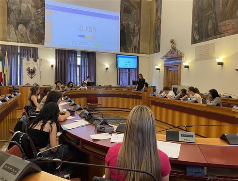 Der Wettbewerb fand vor beeindruckender Kulisse statt: der Saal des Trentiner Gemeinderats im Palazzo Thun.
An der Rednerbühne Caterina Perini vom Gymnasium “Sophie Scholl” aus Trient. 