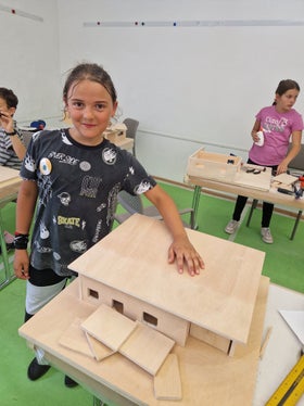 Ihr eigenes Traumhaus konnten die Schülerinnen und Schüler in der Modellbau-Werkstatt“ realisieren, im Bild Michele. (Foto: LPA/Begabungs- und Begabtenförderung der Pädagogischen Abteilung der Deutschen Bildungsdirektion/Eva Enderle)