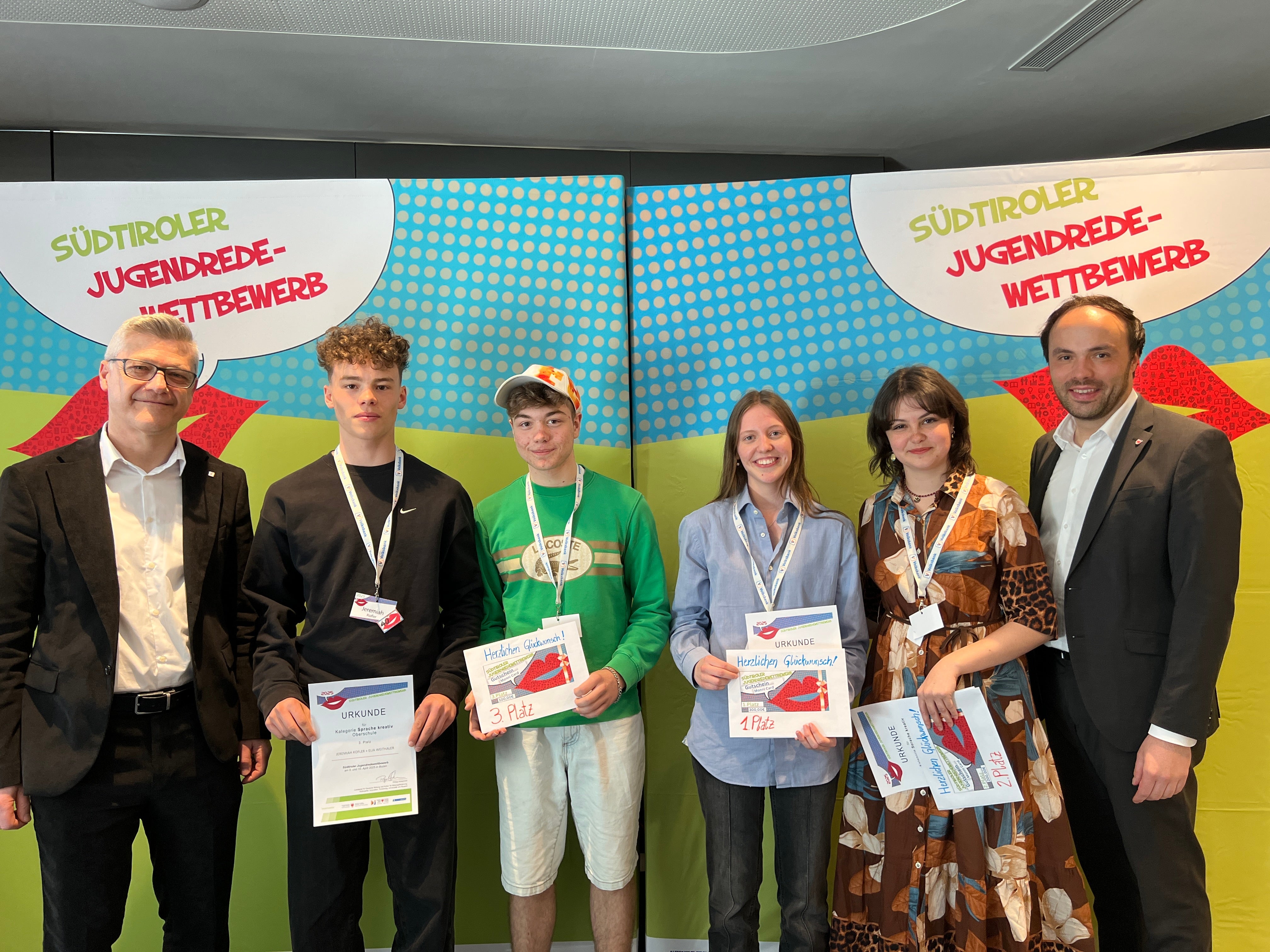 Südtiroler Jugendredewettbewerb 2025: Sieger Sprache kreativ (von links): Mariano Paris (Leiter Corporate Communication und Marketin Volksbank), 3. Platz Jeremiah Kofler und Elia Weithaler, 1. Platz Helena Wierer, 2. Platz Olivia Kaufmann, Landesrat Philipp Achammer (Foto: LPA/Anita Demetz)