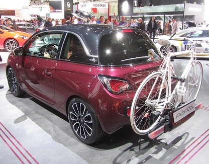 Grazie a una nuova normativa, il trasporto delle biciclette su portabici montati sul veicolo diventa molto più semplice. (Foto: https://commons.wikimedia.org/wiki/File:Opel-Adam_berry-red_w-Flexfix-bike-carrier_IAA2013_LWS2864.jpg autore L.Willms)