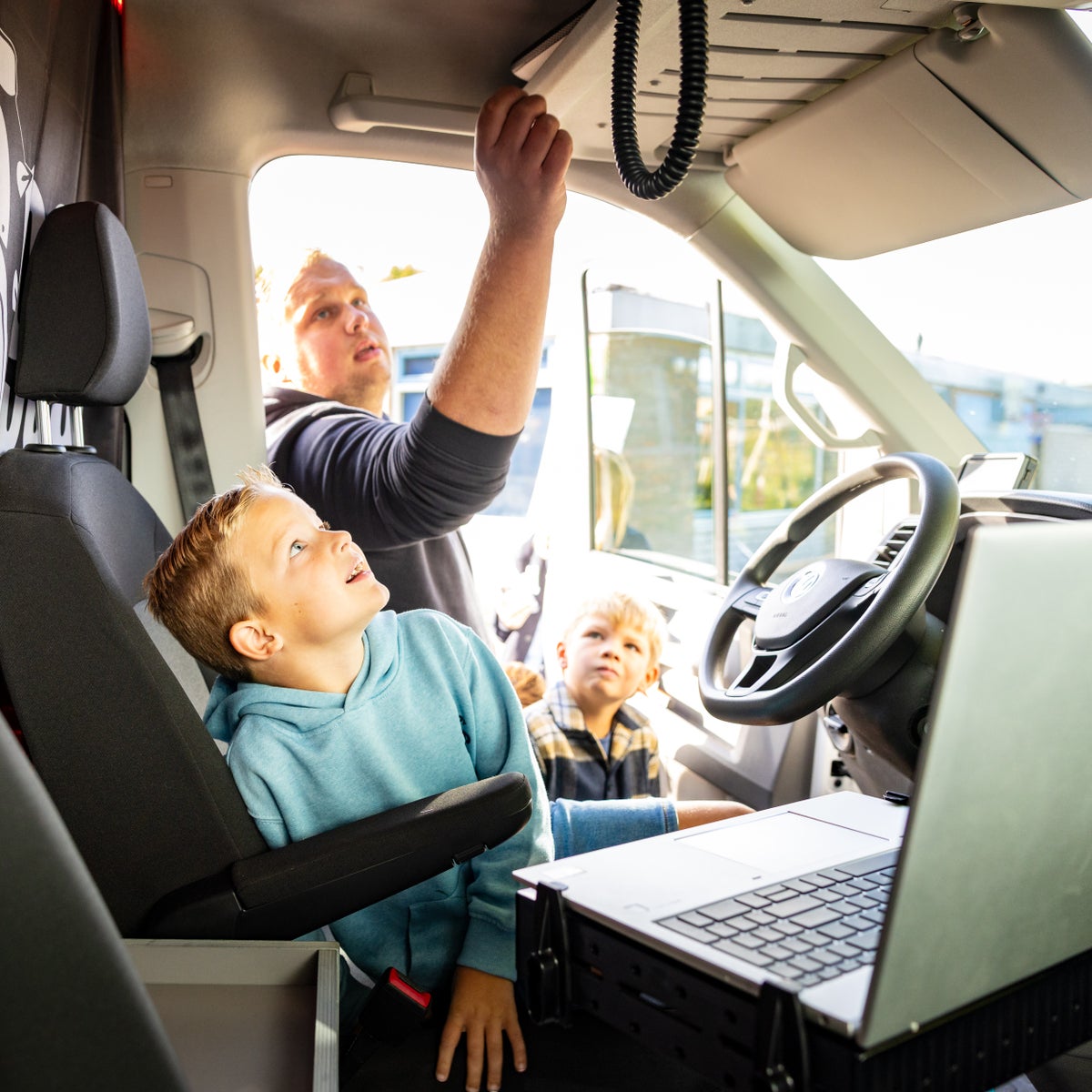 Kind kijkt mee in de bus van een monteur van Evides