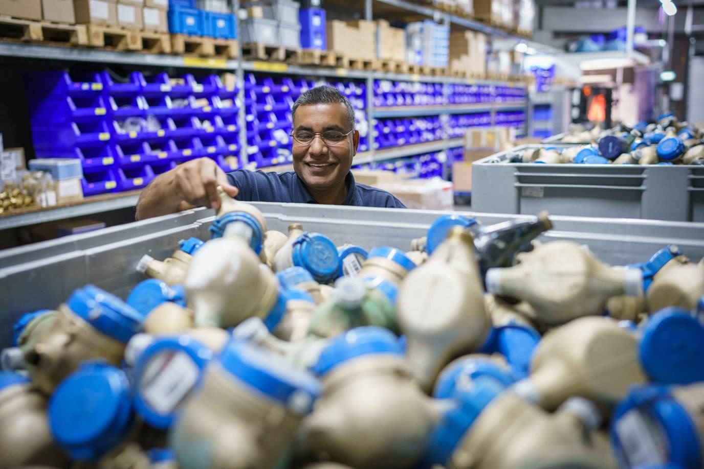 Magazijnmedewerker in een magazijn met transport-en leidingsmateriaal