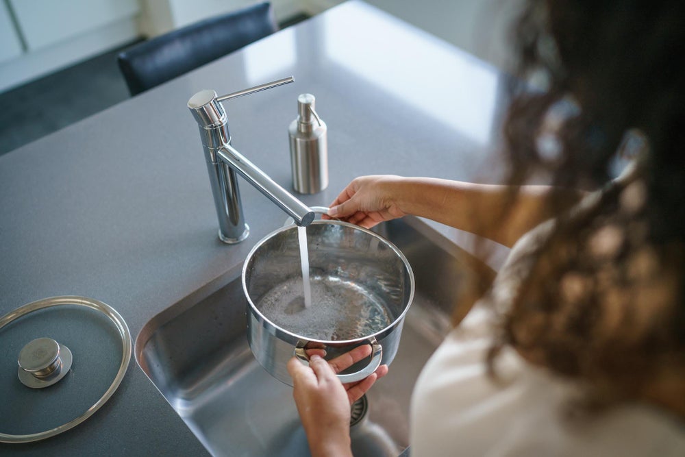 Vrouw vult pan met water