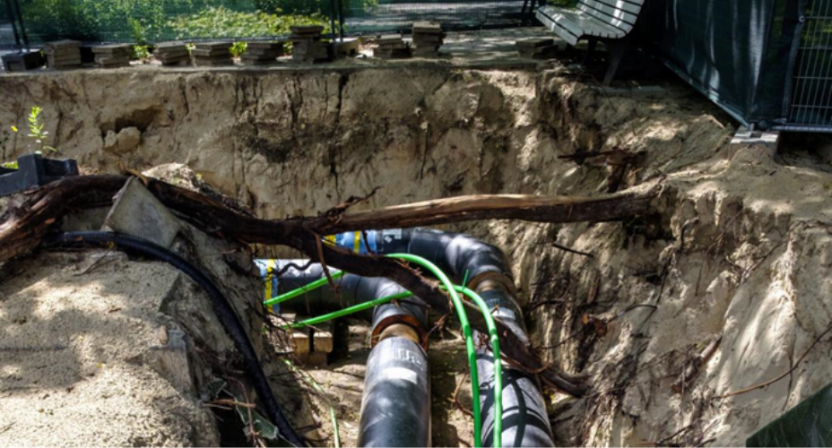 Uitgegraven grond in een straat met leidingen en kabels