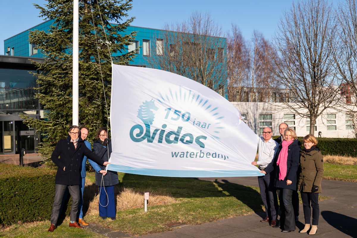 Evides directie met de jubileumvlag.