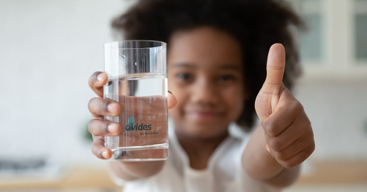 Meisje met glas water en duim omhoog