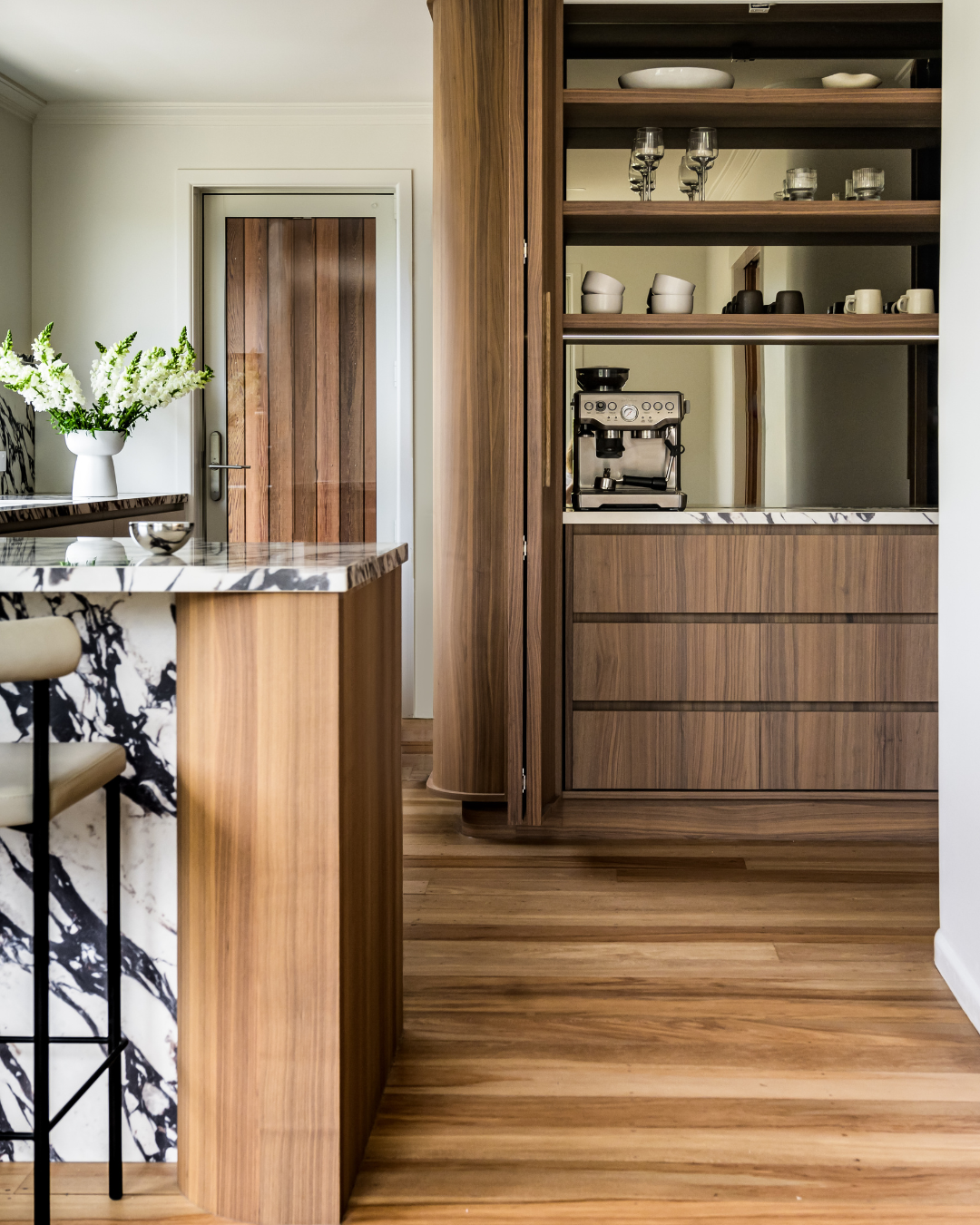 A kitchen with a marble countertop and a wood floor - shinnoki frozen walnut wood veneer