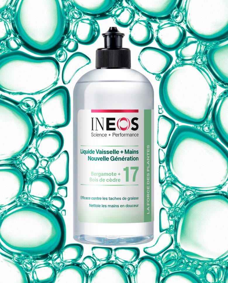 a photo of the french version of the bergamot and cedarwood 2-in-1 wash on a teal bubbly background