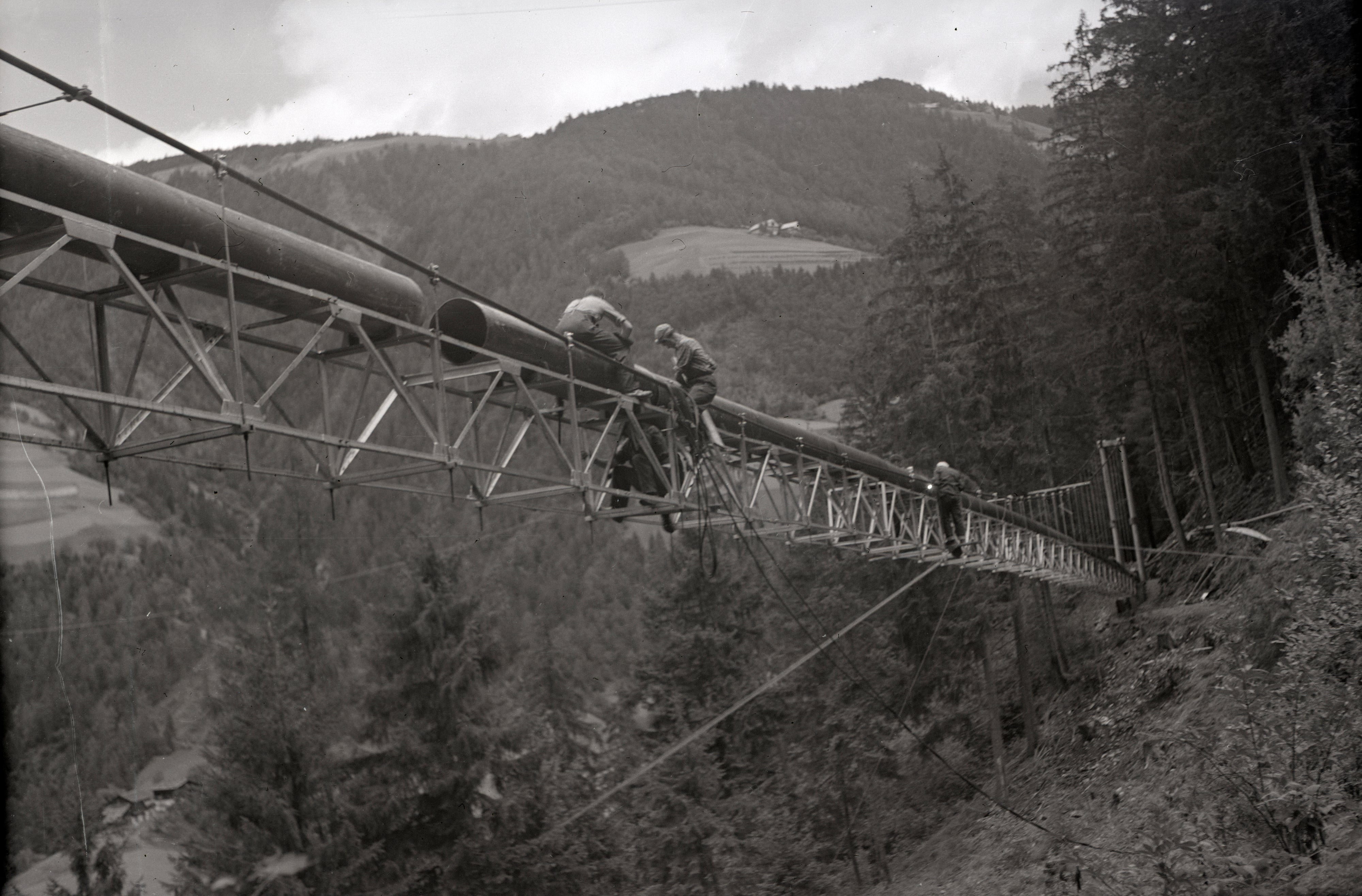 Un prerequisito per la massiccia espansione delle aree frutticole fu una sufficiente irrigazione delle colture. (Immagine: montaggio di una derivazione dal rio Luson, 1956). ApBz, archivio fotografico Mario e Benjamin Geat, Nr. 2122.