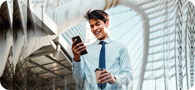 Image of a man wearing a tie, wearing a white shirt and holding a mobile phone.