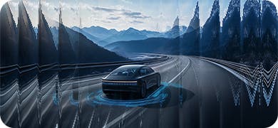 Image of a car driving on a road with mountain views.