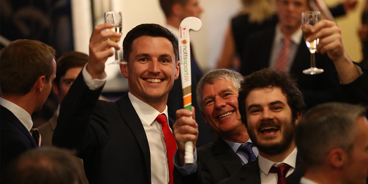 Men Holding Champagne and Hockey sticks Celebrating at the England Hockey Awards