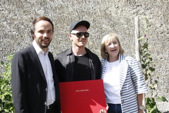 Auf dem Foto zu sehen: Der Preisträger Sven Sachsalber zwischen Südtirols Kulturlandesrat Philipp Achammer und Tirols Kulturlandesrätin Beate Palfrader im Gemeinschaftsgarten in Glurns. Foto: Land Südtirol, Nicole Abler.