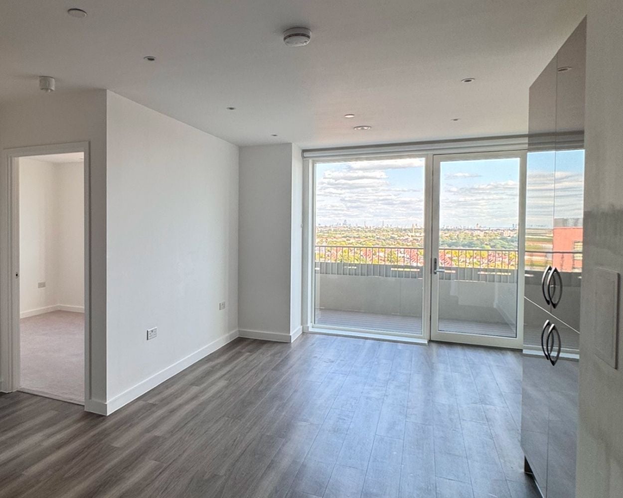 Photo showing the open-plan dining and living area featuring door to the balcony