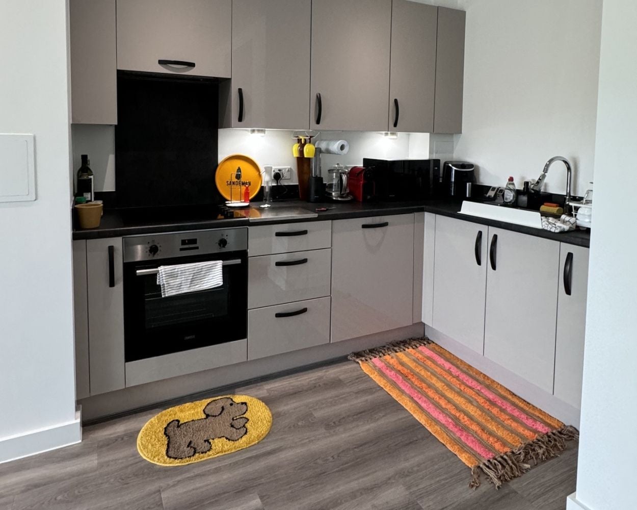 Photo of the kitchen area featuring integrated oven, hob and extractor fan