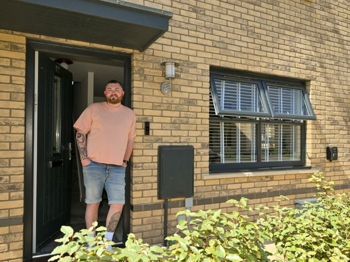 Ethan smiles as he stands in the doorway to his new home.