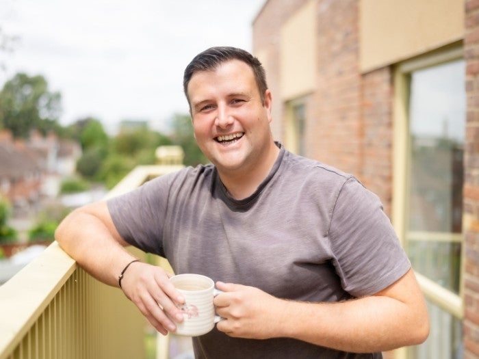 Connor relaxes on his balcony whilst drinking a tea.