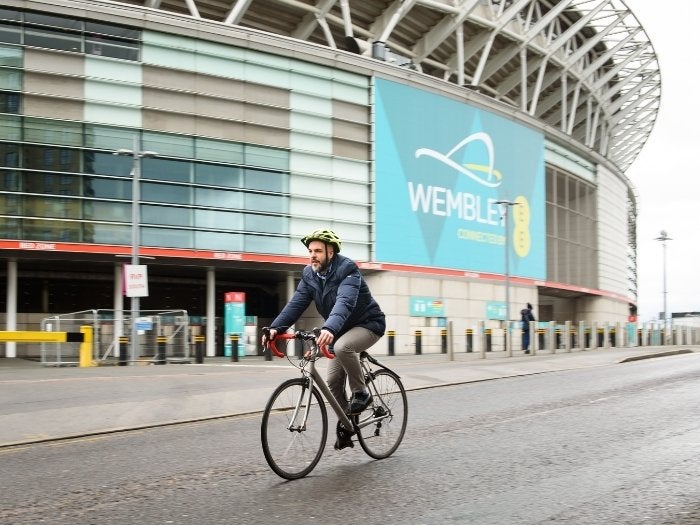 Daniel rides his bike past Wembley Stadium