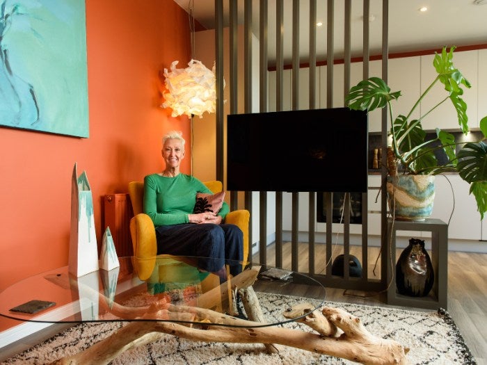 Moira sits in her armchair in her open plan living room
