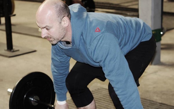 Hartpatiënt Paul tilt een halter op.