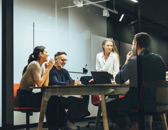 4 professionals in bespreking aan tafel.