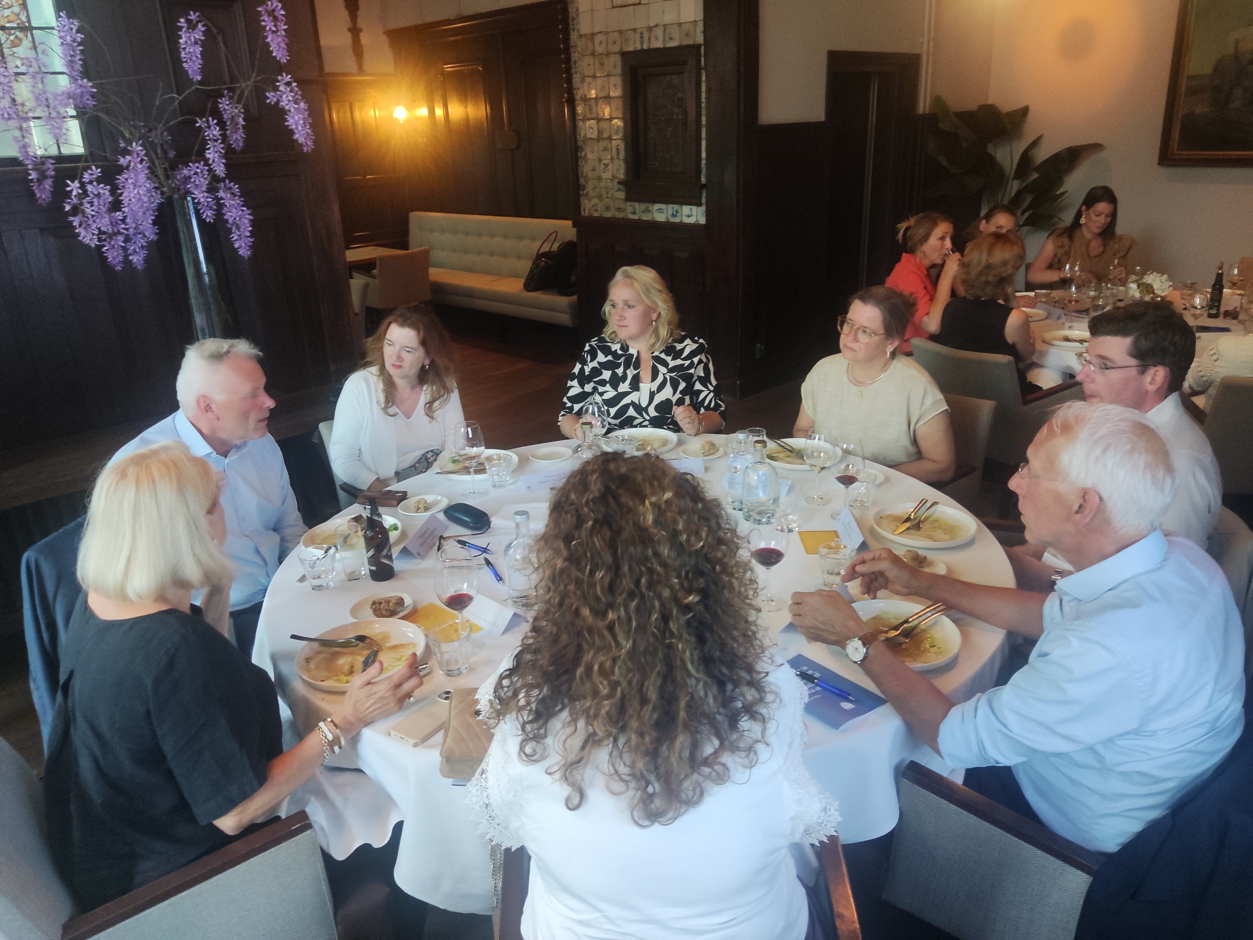 Een groep mensen die rond een tafel zit