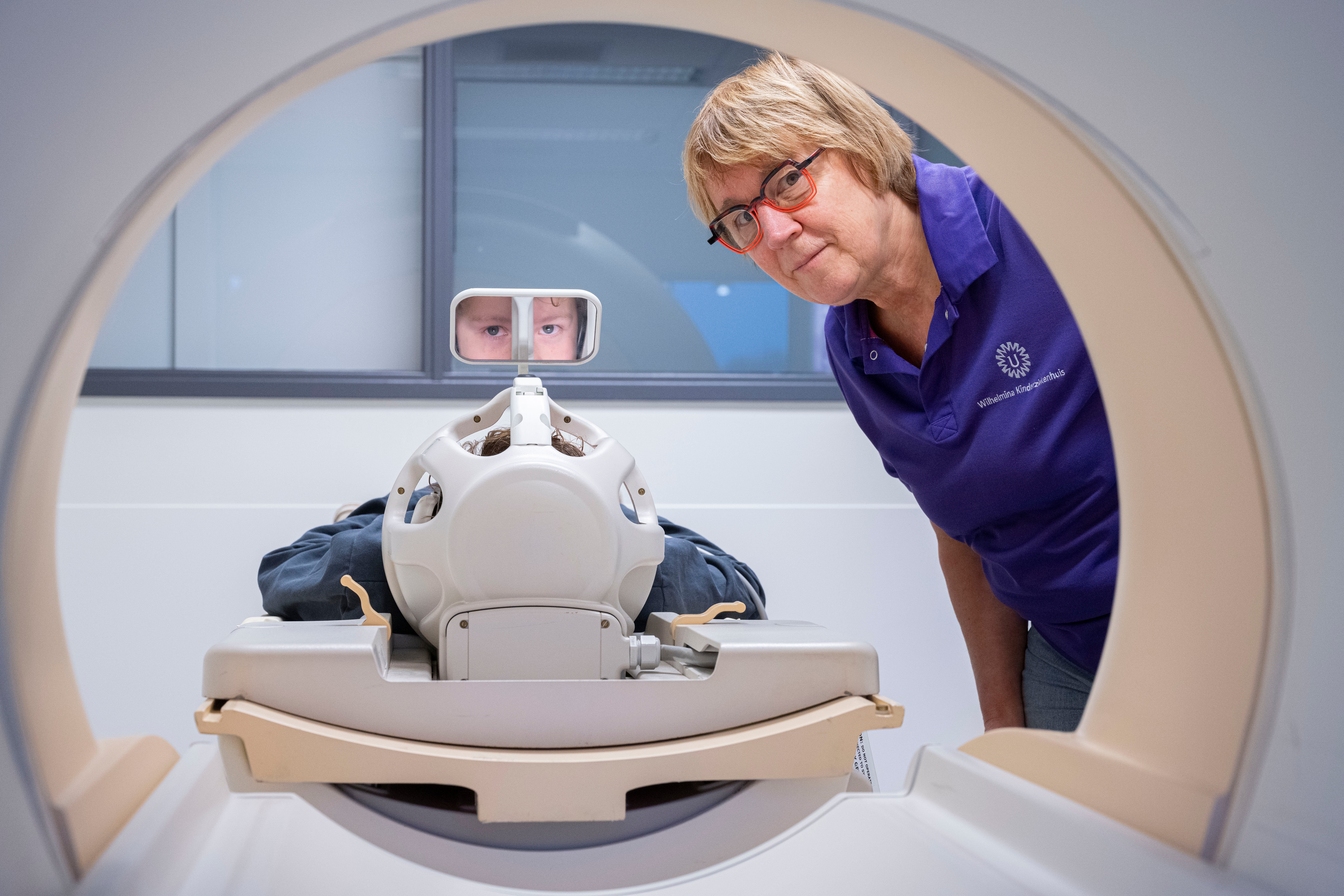 jongen kan ouders zien via een spiegeltje in de oefen MRI