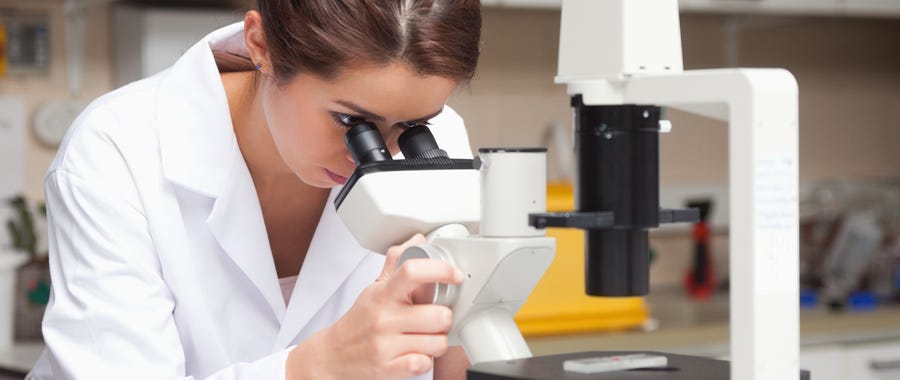 Een onderzoeker kijkt door een microscoop