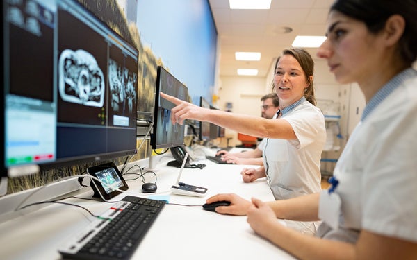 MR-Linac controlroom: twee onderzoekers bekijken een scan op een computer