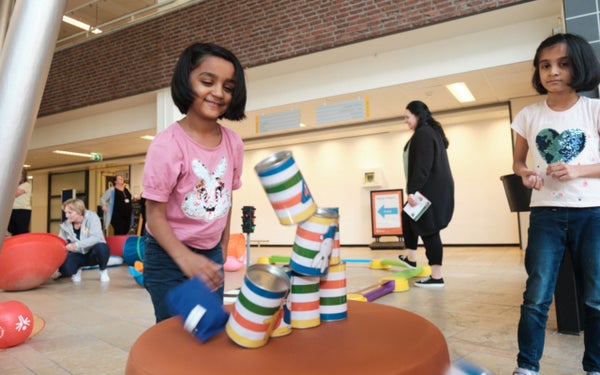 Kinderen spelen met blikken in het WKZ op Nijntje Beweegdag.