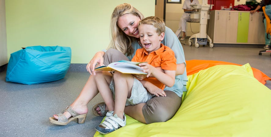 Vrouw met kind op schoot, samen lezn ze een boek