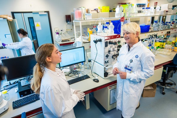 Jeanette Leusen en collega in laboratoriumjassen in het laboratorium.