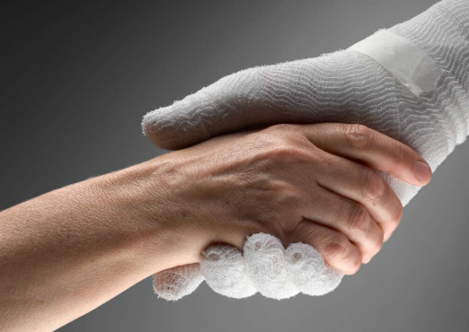 Een close-up van een hand die een hand met een handschoen aan vasthoudt